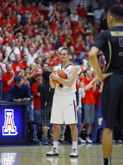 Arizona guard T.J. McConnell (4) holds on to the ball as the final seconds tick off the clock securing their 71-62 win over the Washington an NCAA college basketball game Saturday, Jan. 4,,  2014 in Tucson, Ariz. (AP Photo/The Arizona Republic, David Kadlubowski)  MARICOPA COUNTY OUT; MAGS OUT; NO SALES