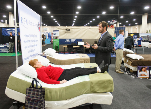 Trent Nelson  |  Tribune file photo
Potential customer Sandy Kinnick tests out a mattress with Eric Landon of R.E.M. Sleep Solutions at the 2013 Salt Lake Home Show. This year's show opens Friday and runs through Sunday at the South Towne Expo Center in Sandy.