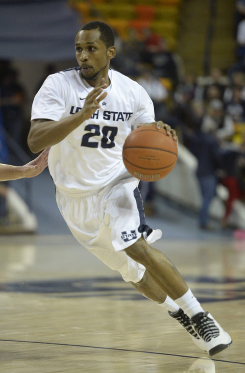 Rick Egan  | The Salt Lake Tribune 

Utah State guard TeNale Roland (20) drives with the ball for the Aggies in basketball action, Utah State vs.Troy, at the Dee Glen Smith Spectrum, in Logan, Friday, December 20, 2013.