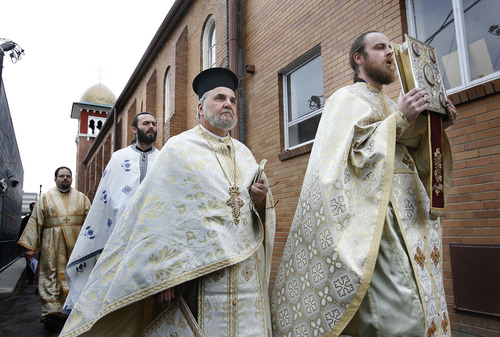Scott Sommerdorf  |  Tribune file photo 
The Rev. Justin Havens (far right), pastor of Saints Peter and Paul Antiochian Orthodox Church, leads the procession around the church before entering for the consecration on Sunday, Jan. 24, 2010. The Rev. Michael Kouremetis follows behind Havens.
