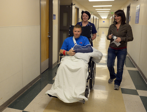 Rick Egan  | The Salt Lake Tribune 

Matt Morgan, is wheeled down the hall at McKay Dee Hospital by Connie M. as Emilee Morgan wake behind, after a press conference, Wednesday, January 15, 2014. Morgan survived an avalanche near the Idaho-Utah border on Saturday,