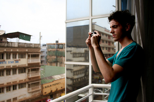 Jeremiah Stettler  |  The Salt Lake Tribune

A.J. Walker stands at the window of his Kampala hotel, snapping photos of the city's commerce-clogged downtown.