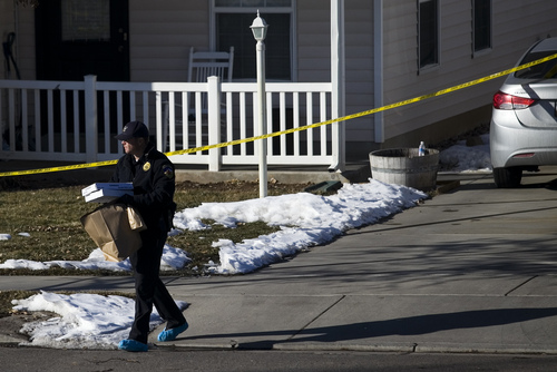 Investigators remove evidence from a home, Friday, Jan. 17, 2014, in Spanish Fork, Utah,  where five people were found dead on Thursday.  A 34-year-old officer shot and killed his wife, mother-in-law and two young children and turned the gun on himself, authorities said Friday.  Spanish Fork police said the five were found dead about 11 p.m. Thursday, when co-workers reported Joshua Boren didn't show up for his night shift as a patrol officer at the Lindon Police Department. (AP Photo/Daily Herald, Mark Johnston)