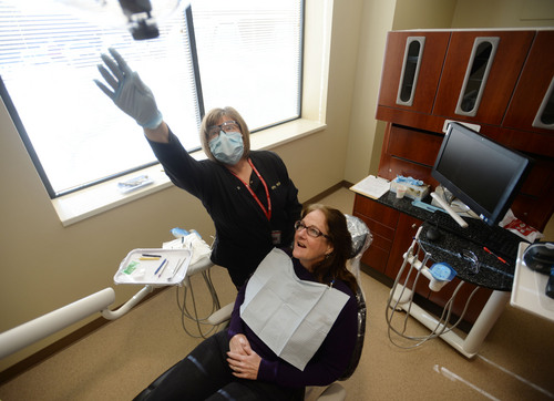 Steve Griffin  |  The Salt Lake Tribune

Dental clinic manager and hygienist, Kathy Harris, reaches for the overhead light as she prepares to clean Mary Hogle-Jahn's teeth for the first time in seven years, at the new 4th Street Dental Clinic in Salt Lake City, Friday, January 17, 2014.
