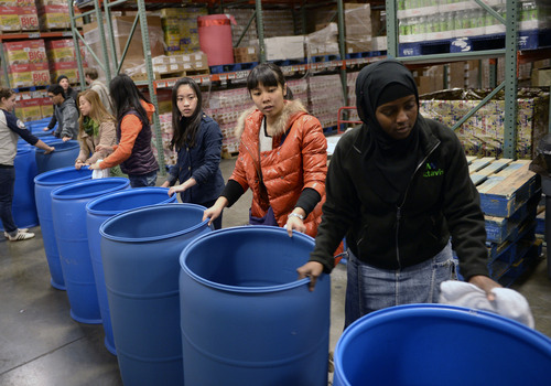 Al Hartmann  |  The Salt Lake Tribune
Student volunteers from Youth City, Americorps, and Juan Diego High School gathered at the Utah Food Bank to clean and organize food barrels to celebrate Martin Luther King Day.  They form a line pushing hundred of the cleaned barrels through the warehouse and up a set of stairs for storage. The students were joined by other private individuals and corporate groups to prepare food boxes and deliver them to elderly and others with food needs.