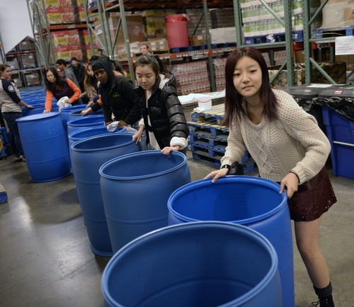 Al Hartmann  |  The Salt Lake Tribune
Student volunteers from Youth City, Americorps, and Juan Diego High School gathered at the Utah Food Bank to clean and organize food barrels to celebrate Martin Luther King Day.  They form a line pushing hundred of the cleaned barrels through the warehouse and up a set of stairs for storage. The students were joined by other private individuals and corporate groups to prepare food boxes and deliver them to elderly and others with food needs.