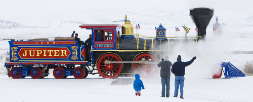 Promontory - Locomotive engineers Richard Carroll (left) and  Ron Wilson (right) and volunteer Kent Brown (center) wave as the run the Jupiter down the tracks during the Winter Steam Festival at the Golden Spike National Historic Site at Promontory, Utah Friday, December 28, 2007.  The Jupiter is an exact replica of the Central Pacific's wood-fired steam locomotive that met the Union Pacific's 119 locomotive on May, 10 1869 in Promontory connecting the east and west. Steve Griffin/The Salt Lake Tribune 12/28/07