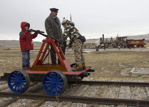 Al Hartmann  |  The Salt Lake Tribune
Brighmam City cub scouts Chance Scouthsen, left,  and Logan Clark, right.  put some muscle into powering a handcart under the eye of Will Lawrence at  Golden Spike National Historic Site visitor center in northwestern Utah Wednesday December 28.   Golden Spike holds its annual Winter Steam Festival on December 28-30 Folks can get up close to tour the locomotive cab, see steam demonstrations as well as take a ride on a handcart.