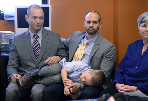 Al Hartmann  |  The Salt Lake Tribune
Plaintiffs Matthew Barraza, left, and Tony Milner, who are legally married, listen to the announcement with their napping son Jesse of ACLU of Utah filing of a lawsuit Tuesday Jan. 21, 2014, in Salt Lake City over Utah's refusal to recognize valid same-sex marriages that occurred before the U.S. Supreme Court issued a stay.