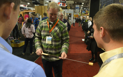 Rick Egan  | The Salt Lake Tribune 

Jeff Larsen, Salomon (left) checks out the Wolf em Stick, made by Tanner and his brother, Spencer Harrison, as they tour the Outdoor Retailers Convention, along with Salt Lake County Mayor Ben McAdams, at the Salt Palace, Thursday, January 23, 2014.