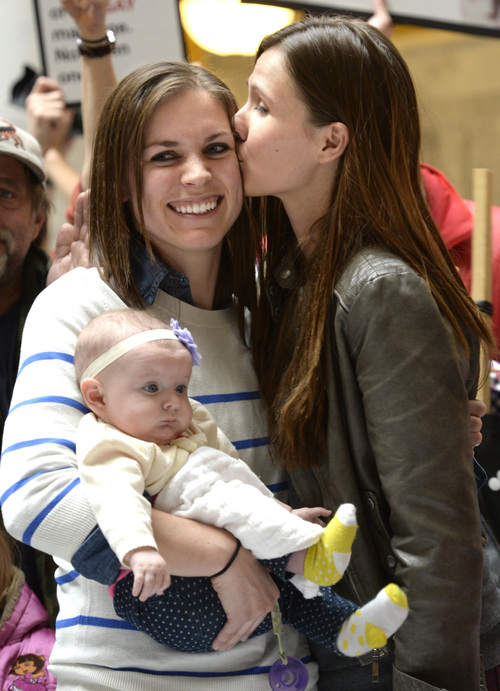 Rick Egan  | Tribune file photo

Megan Berrett gets a kiss from wife Candice Berrett as she holds their daughter Quinn. The couple spoke at a recent rally at the State Capitol urnging Utah Gov. Gary Herbert to protect rights of families like theirs.