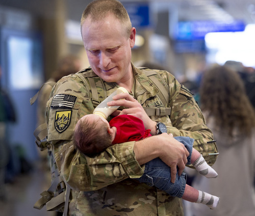 Steve Griffin  |  The Salt Lake Tribune

Master Sgt. Kim Peterson, of the Utah Army National Guardís 204th Maneuver Enhancement Brigade, holds his two-month old son, Kellen, for the first time after  returning to Utah from a 10-month deployment to Afghanistan. Peterson, from Richfield, was in Afghanistan when his son was born. He was met at the Salt Lake City International Airport by his wife, Staci, and their children, Kollin, Cassidy, Alissa and Jacob. The mission of the 204th was to conduct base operations and base defense for U.S. military installations in Northern Afghanistan in support of Operation Enduring Freedom. Soldiers returned home at the Salt Lake City International Airport Friday, January 24, 2014.