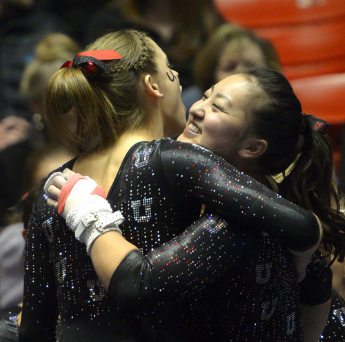 Rick Egan  | The Salt Lake Tribune 

Corrie Lothrop hugs Breanna Hughes after her routine on the bars for the Utes, in Pac12 gymnastics competition, Utah vs. UCLA, at the Huntsman Center, Saturday, January 25, 2014.