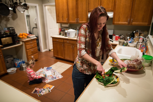 Maggie Barcellano prepares dinner at her father's house in Austin, Texas on Saturday, Jan. 25, 2014. Barcellano, who lives with her father, enrolled in the food stamps program to help save up for paramedic training while she works as a home health aide and raises her three-year-old daughter. Working-age people now make up the majority in U.S. households that rely on food stamps, a switch from a few years ago when children and the elderly were the main recipients.  (AP Photo/Tamir Kalifa)
