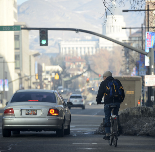 Al Hartmann  |  The Salt Lake Tribune
A bicyclist rides in downtown Salt Lake City Monday morning December 30 as unhealthy air increases. The Utah Division of Air Quality rated the air in the orange range with a health advisory for elderly and persons with existing heart or lung disease to stay indoors and reduce physical activity.
