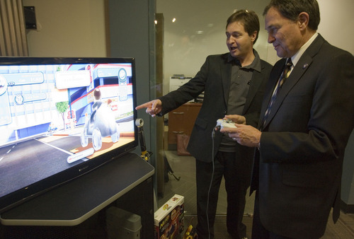 Jim Urquhart  |  Tribune file photo
Jon Dean executive producer at Electronic Arts, left, and Utah Governor Gary Herbert play Monopoly Streets Wednesday, July 21, 2010 at Electronic Arts in Salt Lake City. The video game studio that worked on the popular "The Sims" PC games and other family-based titles, has laid off part of its staff to focus on mobile gaming, it was announced Thursday, Jan. 30, 2014. Gaming publisher Electronic Arts, headquartered in Redwood Shores, Calif., confirmed the restructuring of the studio but would not say how many employees were let go