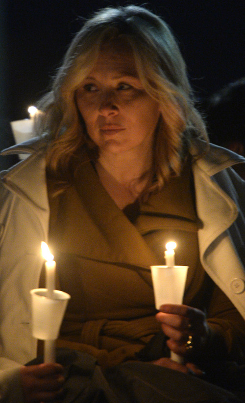 Rick Egan  | The Salt Lake Tribune 

Nanette Wride, wife of Cory Wride, holds a candle, at the candlelight vigil in honor of Sgt. Cory Wride and injured Deputy Greg Sherwood, in Spanish Fork, Sunday, February 2, 2014.  Johnny Revill , family spokesman is on the right.