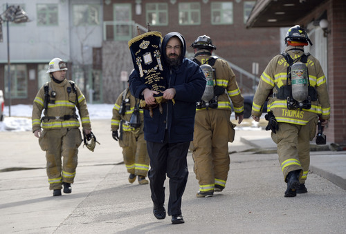 Francisco Kjolseth  |  The Salt Lake Tribune
Rabbi Benny Zippel removes one of two Torah scrolls for safekeeping after smelling smoke and calling the fire department to the Chabad Lubavitch of Utah Jewish center at 1760 S. 1100 East in Salt Lake City on Monday, Feb. 3, 2014. Several children from the day care were safely removed while the cause of the smoke is under investigation.