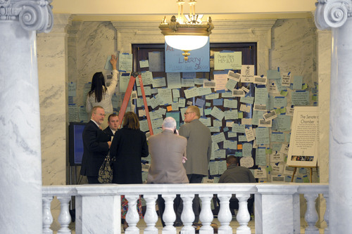 Al Hartmann  |  The Salt Lake Tribune 
People stop by the entrance doors to the Senate at the Utah State Capitol Monday morning February 3, 2014, to see it plastered with hundreds of messages to pass SB100. SB100 is sponsored by Senator Stephen Urquhart, R-St. George, left. The bill modifies the Utah Antidiscrimination Act and Utah Fair Housing Act to address discrimination on the basis of sexual orientation and gender identiity.