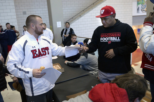 Al Hartmann  |  The Salt Lake Tribune 
East High School football coach Brandon Matich congratulates Ula Tolutau after he signed letter of intent to play football at Wisconsin during a signing ceremony Wednesday February 5, 2014.