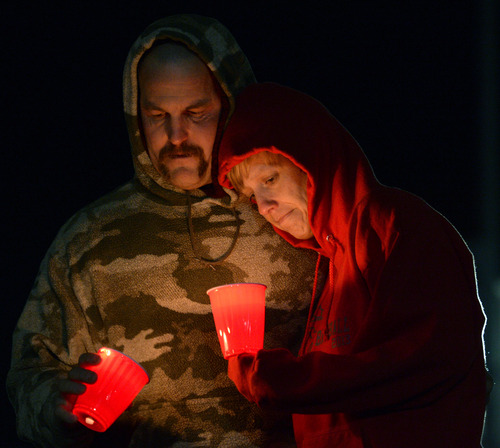 Rick Egan  | The Salt Lake Tribune 

Jeff and Sheri Jones, Spanish Fork, hold candles at the candlelight vigil in honor of Sgt. Cory Wride and injured Deputy Greg Sherwood, in Spanish Fork, Sunday, February 2, 2014.  Johnny Revill , family spokesman is on the right.