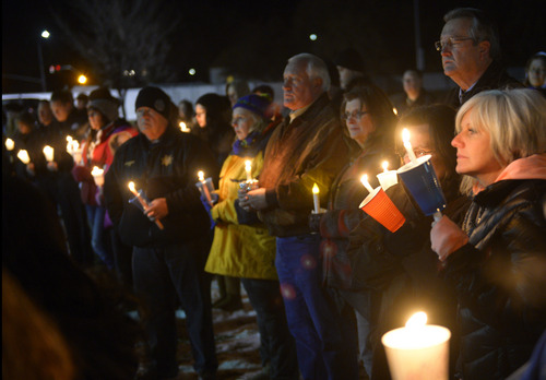 Rick Egan  | The Salt Lake Tribune 

Supporters hold candles at the candlelight vigil in honor of Sgt. Cory Wride and injured Deputy Greg Sherwood, in Spanish Fork, Sunday, February 2, 2014.  Johnny Revill , family spokesman is on the right.