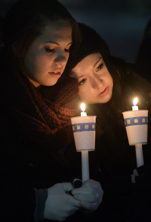Rick Egan  | The Salt Lake Tribune 

Amanda Tuttle (left) and Caitlyn Cody (right) hold candles at the candlelight vigil in honor of Sgt. Cory Wride and injured Deputy Greg Sherwood, in Spanish Fork, Sunday, February 2, 2014.