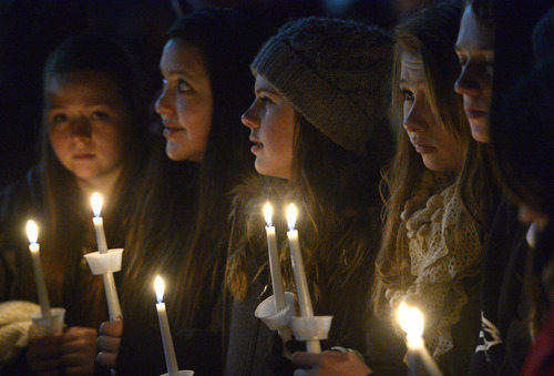 Rick Egan  | The Salt Lake Tribune 

A group of young girls sing a song with the crowd at the candlelight vigil in honor of Sgt. Cory Wride and injured Deputy Greg Sherwood, in Spanish Fork, Sunday, February 2, 2014.  Johnny Revill , family spokesman is on the right.