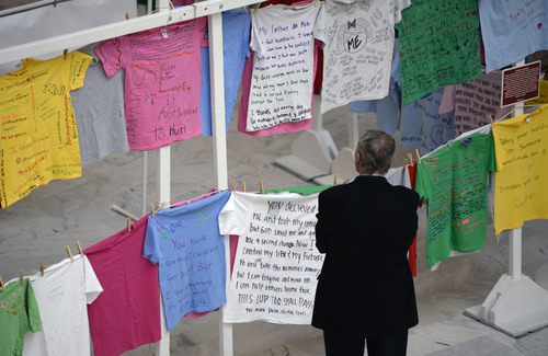 Al Hartmann  |  The Salt Lake Tribune 
A man reads T-shirt messages from the "Clothesline Project" in the Utah Capitol Rotunda Monday February 3, 2014. The T-shirts on display were created by survivors of abuse or in honor of someone who has died in violence against women. The purpose of the display is to increase awareness of the impacts of violence against women and to create a healing opportunity for those who are suffering. The display was brought by the Salt Lake Domestic Violence Coalition.