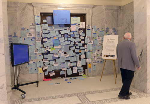 Al Hartmann  |  The Salt Lake Tribune 
Senate security official looks at hundreds of messages to pass SB100 that plaster the entrance doors to the Senate at the Utah State Capitol Monday morning February 3, 2014. SB100 is sponsored by Sen. Stephen Urquhart, R-St. George. The bill modifies the Utah Antidiscrimination Act and Utah Fair Housing Act to address discrimination on the basis of sexual orientation and gender identiity.