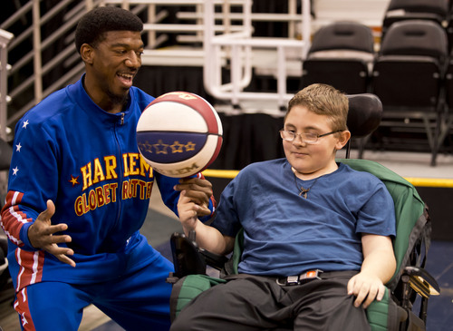 Lennie Mahler  |  The Salt Lake Tribune
Austin Bennett, a 12-year-old with Duchenne muscular dystrophy, spins a basketball on his finger with help from Harlem Globetrotters player Buckets Blakes on Friday, Feb. 7, 2014, at EnergySolutions Arena. Bennett will meet and watch the Harlem Globetrotters play the World All-Stars on Monday, Feb. 10, as a "bucket list" item fulfilled by the Children and the Earth charity.