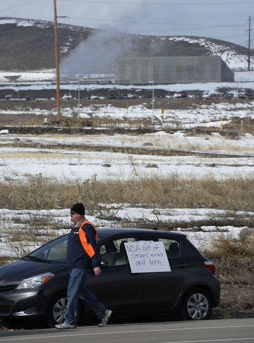 Francisco Kjolseth  |  The Salt Lake Tribune
Volunteer Trent Fordham joins the people of Restore The Fourth-Utah along with others who share their concerns of the NSA, in background, to pick up trash along Redwood Road outside the Utah Data Center on Tuesday, Feb. 11, 2014. The clean up is meant to double as a protest against the NSA as a poster on a car reads "NSA out of citizens' emails and texts."