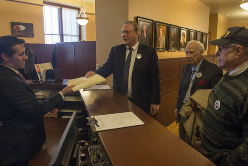 Rick Egan  | The Salt Lake Tribune 

Justin Lee (left), deputy director of elections, accepts petitions from Jared Beck, Hal Massey and Wally McCormick, of the Independent American Party, at the lt. governor's office at the State Capitol, Friday, February 14, 2014.