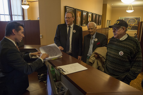 Rick Egan  | The Salt Lake Tribune 

Justin Lee (left), deputy director of elections, checks out petitions from Jared Beck, Hal Massey and Wally McCormick, of the Independent American Party, at the lt. governor's office at the State Capitol, Friday, February 14, 2014.