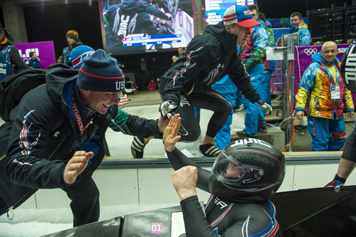 KRASNAYA POLYANA, RUSSIA  - JANUARY 17:
USA bobsled Head Coach Brian Shimer, left, congratulates pilot Steven Holcomb, as Christopher Fogt goes to celebrate with brakeman Steven Langton, not pictured, after competing in the men's two-man bobsled at Sanki Sliding Center during the 2014 Sochi Olympics Monday February 17, 2014. USA-1 with Steven Holcomb, of Park City, Utah, and Steve Langton, of Melrose, Mass., won the bronze medal with a time of 3:46.27.
(Photo by Chris Detrick/The Salt Lake Tribune)