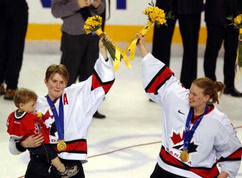 Danny La  |  Tribune file photo
Members of the Canadian team raise flowers during the medals ceremony.  Canada beats the USA by a score of 2-3 to capture the gold medal.