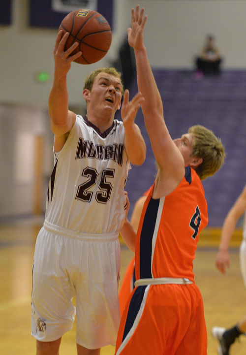 Keith Johnson | The Salt Lake Tribune

Morgan's Ben Saunders (25) shoots over Timpview's Riley Corbin (4)during the finals of the Riverton Holiday Tournament in Riverton, Utah, December 31, 2013.