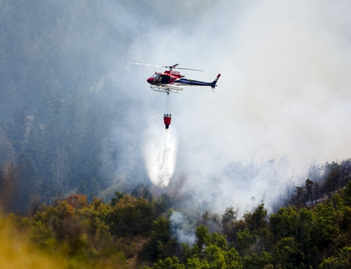 Kim Raff | The Salt Lake Tribune
Helicopters dump water on a wildfire off Highway 40 outside of Heber in Wasatch County,Utah on August 19, 2012.