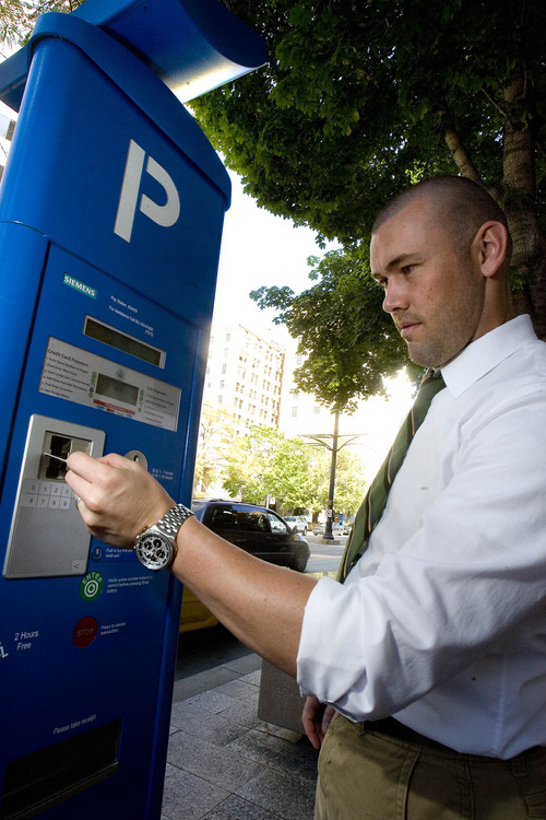 Paul Fraughton  |   The Salt Lake Tribune
Chad Golsan, of Salt Lake City, goes through the steps to pay for parking at a  parking kiosk on Main Street. A new opinion poll says a majority of those surveyed like the kiosks and find them easy to use.  Wednesday, August 21, 2013
