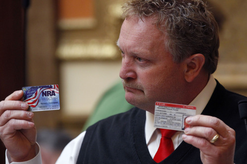 Al Hartmann  |  The Salt Lake Tribune
Rep. Rich Cunningham, R-South Jordan holds up his NRA card and Utah concealed carry permit during debate on 2HB 114 Second Amendment Preservation Act Friday March 8 in the Utah House of Representatives.