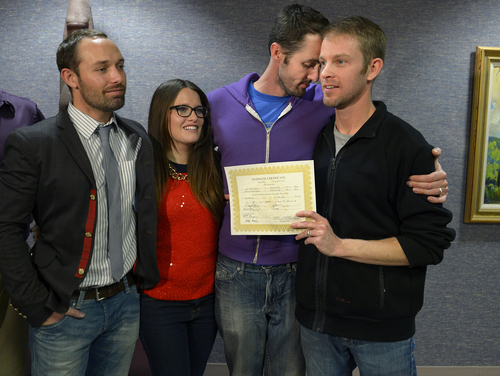 Scott Sommerdorf   |  The Salt Lake Tribune
Michael Ferguson leans into his husband Seth Anderson after they were married at the Salt Lake County offices, Friday December 20, 2013. With them are friends Blake Ferguson, left, and Danielle Morgan. Michael Ferguson and Seth Anderson, (holding their marriage certificate)  were the first couple to be married under the now legal same sex marriage decision handed down by a federal judge just minutes before their ceremony.