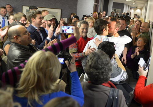Keith Johnson | The Salt Lake Tribune

A crowd applauds outside the Salt Lake County clerks office, Friday, December 20, 2013 after Salt Lake Mayor Ralph Becker, center, performed the wedding for a gay couple who obtained a marriage license after a federal judge in Utah struck down the state's ban on same-sex marriage, saying the law violates the U.S. Constitution's guarantees of equal protection and due process. Hundreds flocked to obtain licenses .