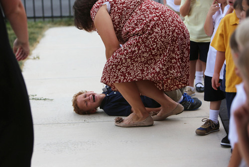 Francisco Kjolseth  |  The Salt Lake Tribune
James Turner, 5, loses control of his emotions after falling from a slide at recess during his first week of kindergarten. His aide, Christy Johnson, comforts him.