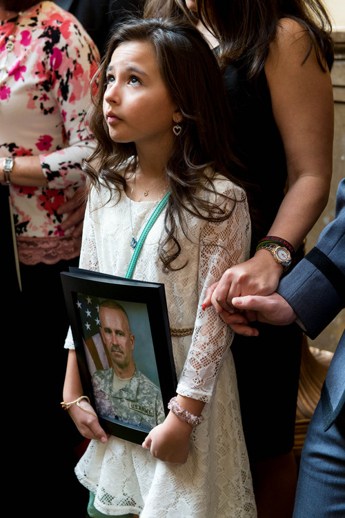 Trent Nelson  |  The Salt Lake Tribune
Kennedy Stapley holds a portrait of her father, Army 1st Sgt. Tracy Stapley, as the House Chamber falls silent to honor the memory of Utah's fallen soldiers, at the State Capitol Building in Salt Lake City, Friday, February 28, 2014.