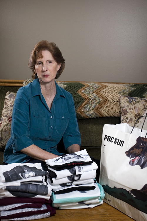 Judy Cox sits for a portrait next to a stack of T-shirts with what she believes are pornographic designs Monday, Feb. 17, 2014, in Orem, Utah. Cox purchased the entire stock of T-shirts for $567 from the PacSun store in Orem believing their display broke Orem's decency code. Cox said she complained about the window display to a store manager and was told the T-shirts couldn't be taken down without approval from the corporate office. (AP Photo/The Daily Herald, Mark Johnston)