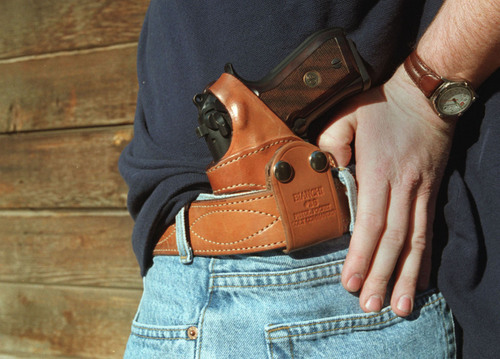 A Beretta 9mm tucked into a waistband holster.  The shirt can be flipped over the entire holster to conceal the weapon.  Al Hartman  |  Tribune File Photo
