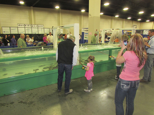 Tom Wharton  |  The Salt Lake Tribune
A little girl tries to catch a fish at the fishing pond at the International Sportsmen's Exposition in Sandy.
