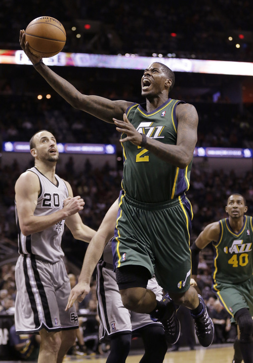 Utah Jazz's Marvin Williams (2) shoots past San Antonio Spurs' Manu Ginobili (20), of Argentina, during the first half of an NBA basketball game, Sunday, March 16, 2014, in San Antonio. (AP Photo/Eric Gay)