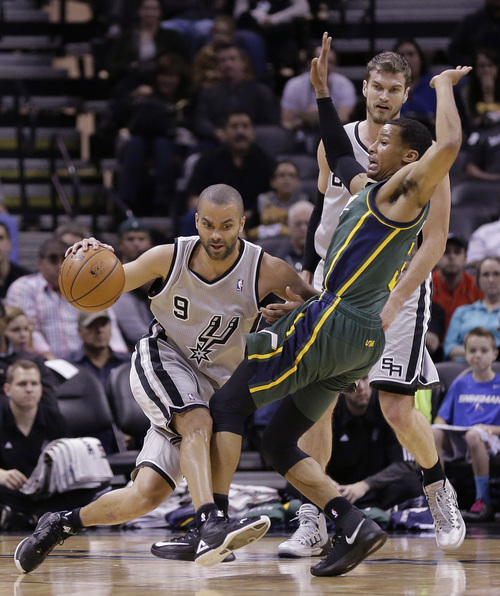San Antonio Spurs' Tony Parker (9), of France, drives around Utah Jazz's Trey Burke (3) during the first half of an NBA basketball game, Sunday, March 16, 2014, in San Antonio. (AP Photo/Eric Gay)