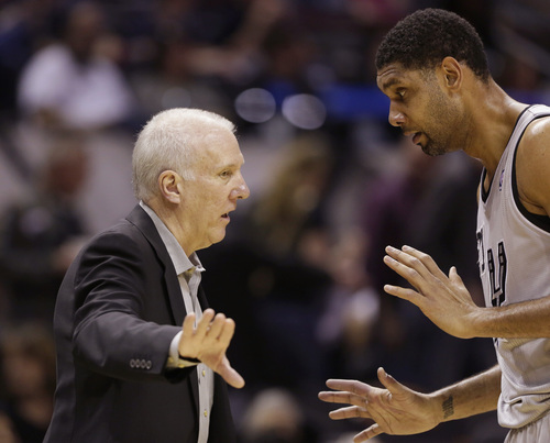 San Antonio Spurs coach Gregg Popovich, left, talks with Tim Duncan, right, during the first half of an NBA basketball game against the Utah Jazz, Sunday, March 16, 2014, in San Antonio. (AP Photo/Eric Gay)